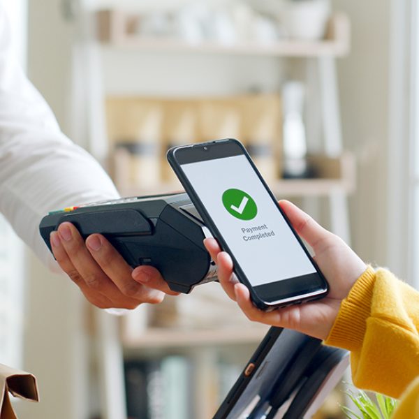 Customer using smartphone for NFC payment at cafe restaurant, cashless, contactless technology and money transfer concept