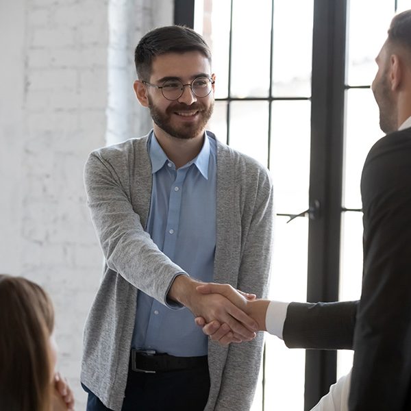 Businessman shake hand greeting get acquainted with smiling male employer at meeting, business partners handshake closing deal at briefing, make agreement at office negotiation, acquaintance concept