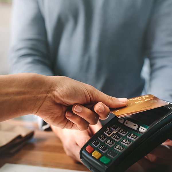 Pharmacist accepting credit card by contactless payment. Woman purchasing products in the pharmacy. Pharmacist hands charging with credit card reader.